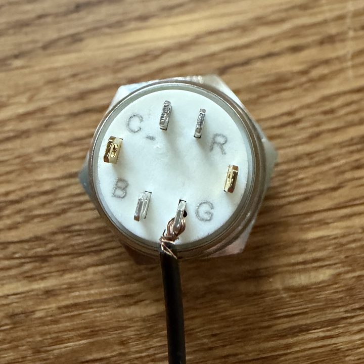 The back of a 16 mm button showing six tabs labelled C minus, R, G and B plus two gold switch tabs